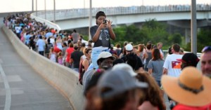 People holding hands crossing the Ravenel Bridge.